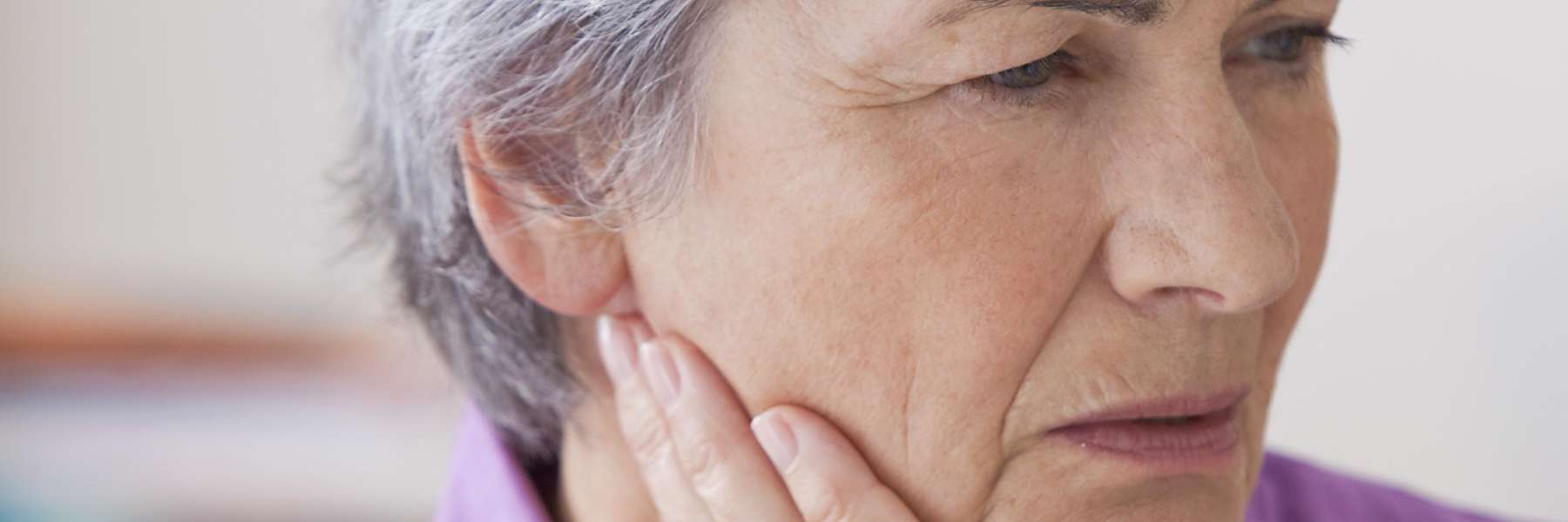 woman holding her right cheek