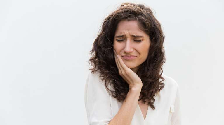 woman in pain holding her right cheek