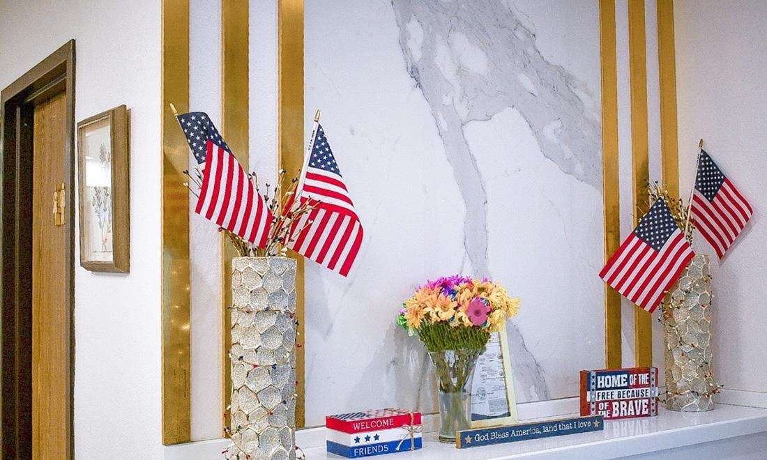 American flags and flowers placed on the front desk of winningsmiles custom dentistry & implant center, fontana ca